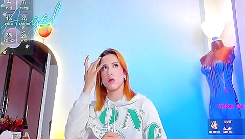 A red haired babe with a tattooed body is playing with a toy